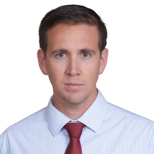 Professional headshot of a man wearing a light blue dress shirt and red tie, looking straight at the camera.